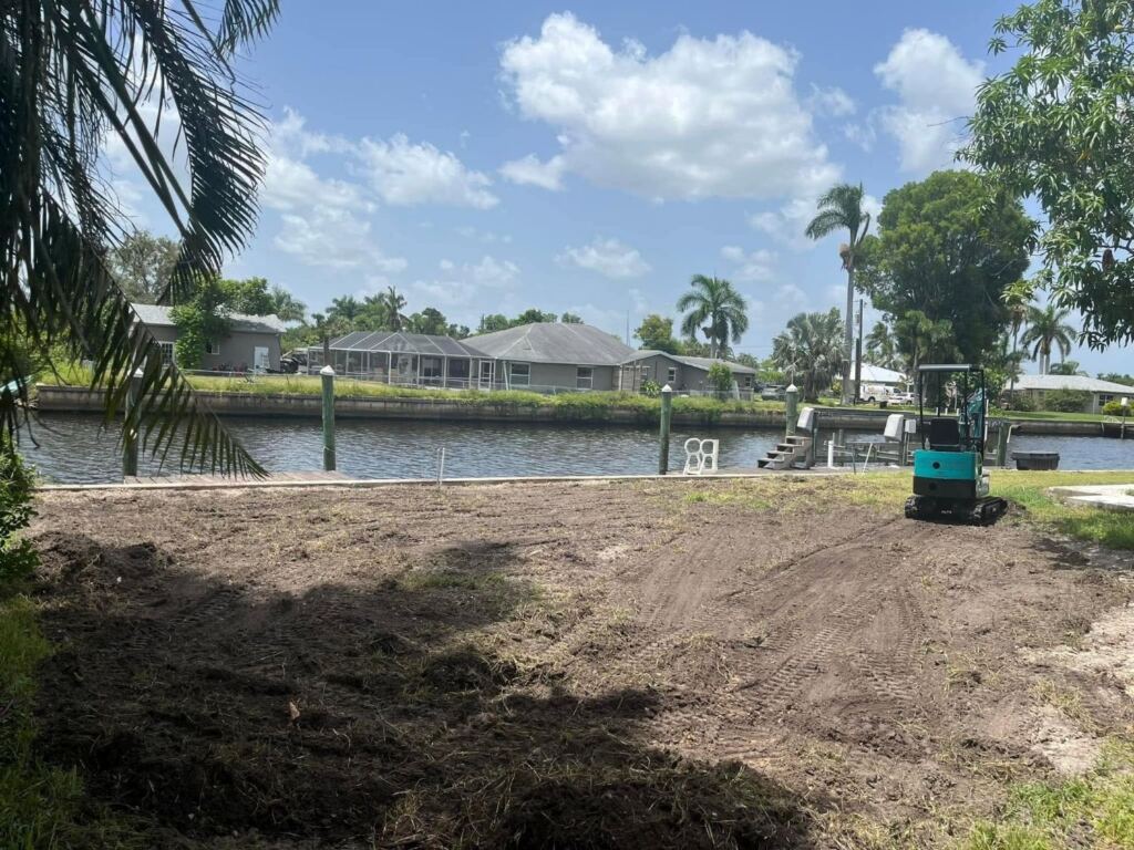 Canal-front backyard cleared and graded with a mini excavator