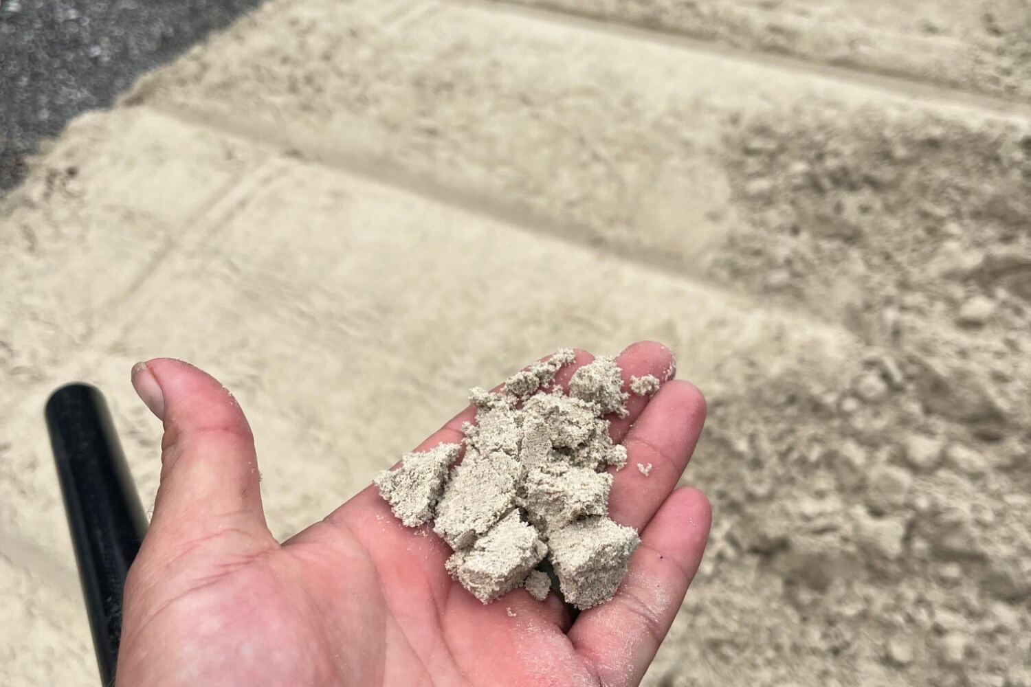 Handful of mason sand from a delivered pile