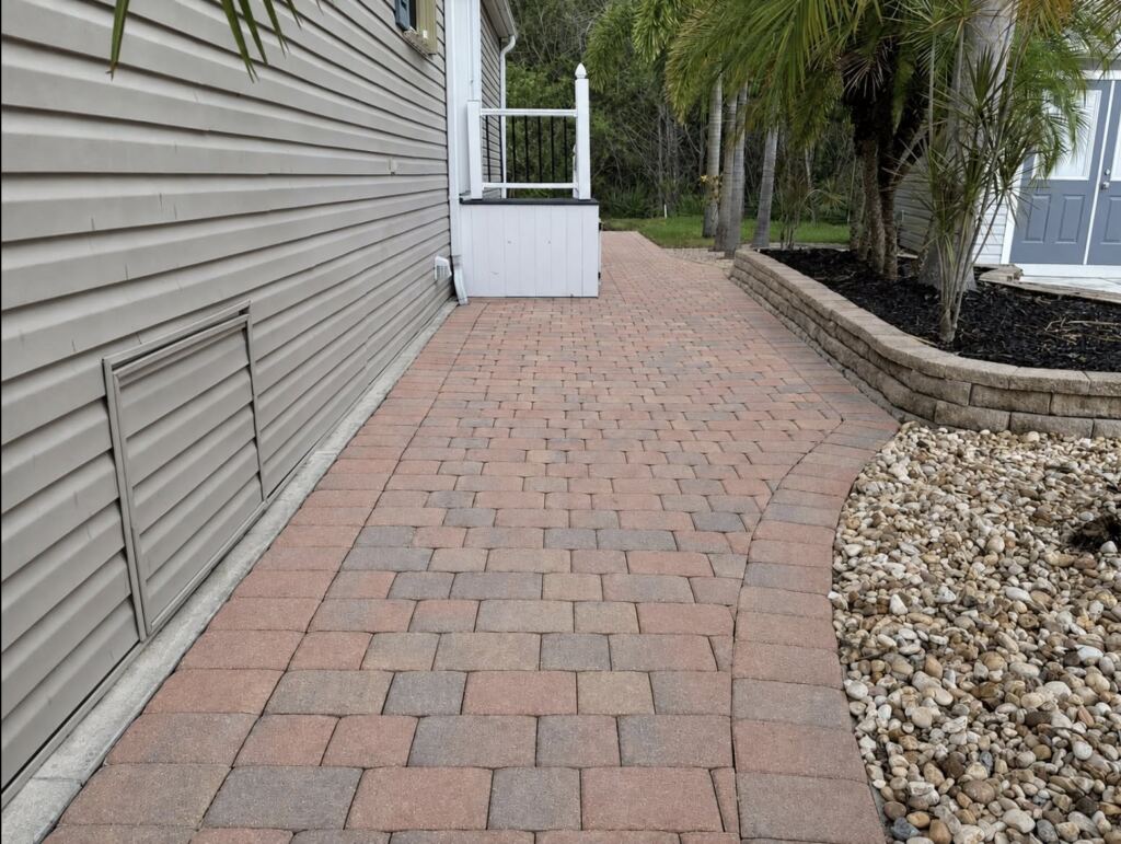 Clean paver walkway beside a home after pressure washing