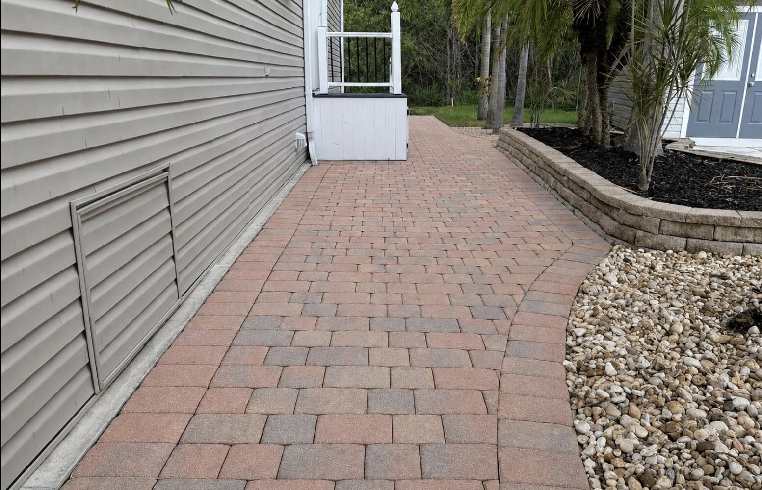 Clean paver walkway beside a home after pressure washing