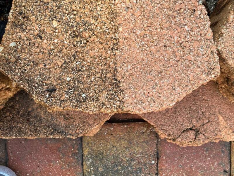 Retaining wall block half cleaned, showing before and after