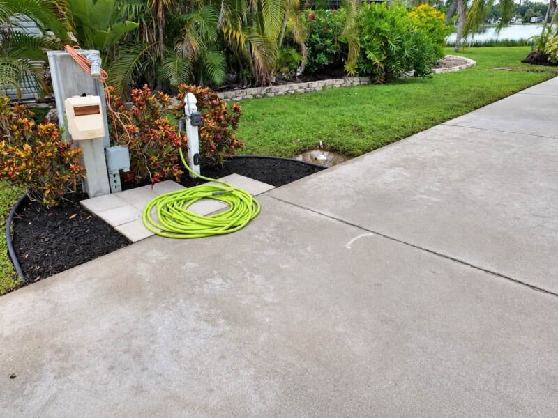 After: edged mulch bed and clean concrete pad at the utility post